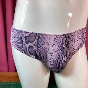 Puede incluir: Ropa interior con estampado de piel de serpiente en morado y negro.