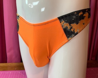 May include: Orange and black patterned underwear with a black seam around the edges.