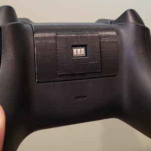 May include: Black wireless gaming controller with a battery indicator showing a full charge.