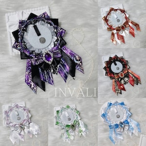 Pode incluir: Uma coleção de distintivos de roseta decorativos em várias cores, incluindo roxo, vermelho e azul. Cada distintivo apresenta fitas em camadas, um elemento circular central e uma joia ou laço decorativo. Alguns têm um colar de pérolas preso.