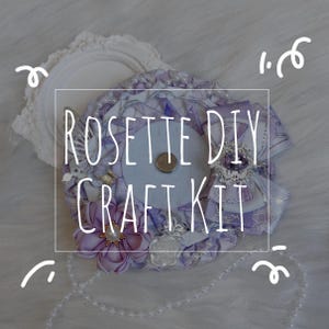 Könnte beinhalten: Ein Rosetten-DIY-Bastelset in Lavendel- und Weißtönen mit Bändern, Verzierungen und einem zentralen Magnetverschluss. Der Text "ROSETTE DIY CRAFT KIT" ist auf dem Bild überlagert. Enthält einen dekorativen Rahmen und eine Perlenkette.