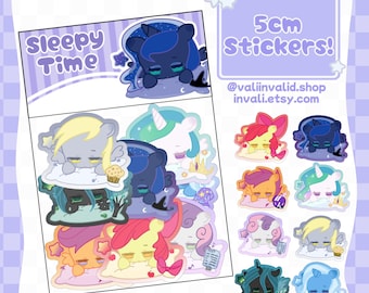 May include: A set of 10 colorful 5cm stickers featuring cartoon ponies sleeping on clouds. The stickers are part of a collection called "Sleepy Time" and are available at @valinvalid.shop and invali.etsy.com.