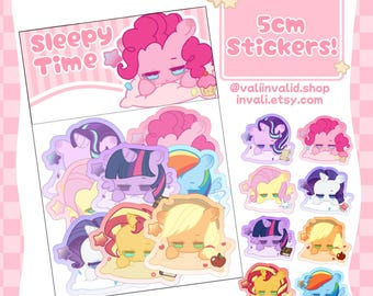 May include: A set of 9 5cm stickers featuring My Little Pony characters in a sleepy pose. The stickers are on a white background with a pink and white checkered border. The text "Sleepy Time" is at the top of the sheet. The text "5cm Stickers!" is at the top right of the sheet. The text "@valiinvalid.shop invalii.etsy.com" is at the bottom right of the sheet.