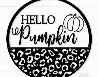 Könnte beinhalten: Ein rundes Schild in Schwarzweiß mit dem Text "Hello Pumpkin" und einer Kürbisgrafik. Die untere Hälfte des Schildes ist ein Leopardenmuster.