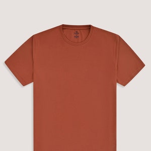 Könnte beinhalten: Ein kurzärmeliges T-Shirt in Rostfarbe mit Rundhalsausschnitt.