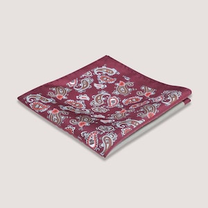 May include: A burgundy paisley pocket square with a white and brown paisley pattern.