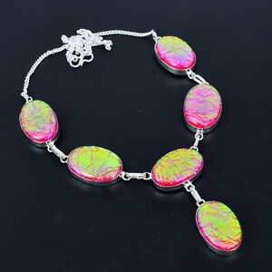 Puede incluir: Collar de plata con piedras ovaladas iridiscentes en rosa y verde. Las piedras est&aacute;n engastadas en biseles de plata y unidas por eslabones de plata. Cierre de mosquet&oacute;n. Dise&ntilde;o llamativo y &uacute;nico.