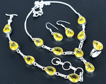 May include: A silver necklace, bracelet, and earrings set with yellow teardrop-shaped gemstones. The set is made of sterling silver and features a delicate chain with a pendant.