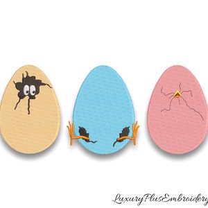 Puede incluir: Tres huevos bordados, uno amarillo con un agujero roto y ojos saltones, uno azul con un agujero roto y uno rosa con un agujero roto.