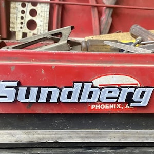 May include: A red metal toolbox with a silver metal nameplate that reads "Sundberg Phoenix, AZ".