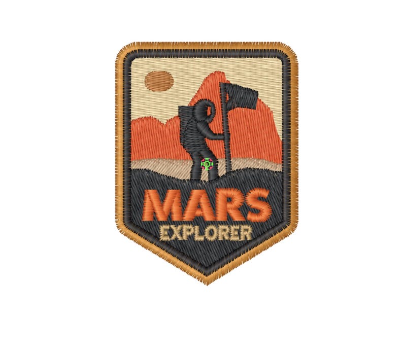 Puede incluir: Un parche bordado marr&oacute;n, negro y naranja con la silueta de una persona sosteniendo una bandera en una cordillera. El texto "MARS EXPLORER" est&aacute; debajo de la imagen.