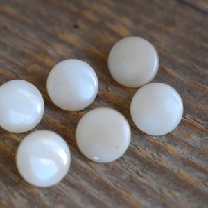 Può includere: Sei bottoni rotondi bianchi con finitura madreperla.
