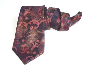 Puede incluir: Una corbata de seda con estampado floral en rojo oscuro, marrón y dorado.