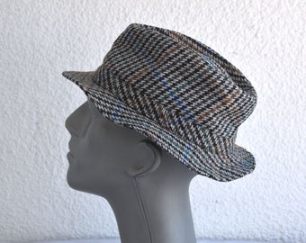 May include: A brown, black, and blue plaid fedora hat.