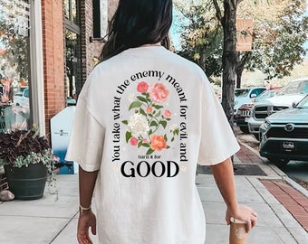 Peut inclure: T-shirt blanc avec un motif floral et le texte "You take what the enemy meant for evil and turn it for GOOD".