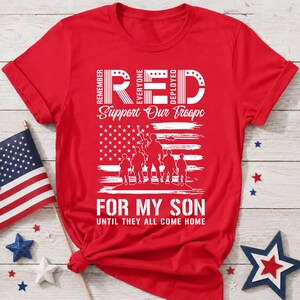 Könnte beinhalten: Ein leuchtend rotes Kurzarm-T-Shirt mit weißem Grafikdruck. Das Design enthält den Text REMEMBER EVERYONE DEPLOYED, Support Our Troops, FOR MY SON und UNTIL THEY ALL COME HOME sowie eine Silhouette von Soldaten und eine Flagge.