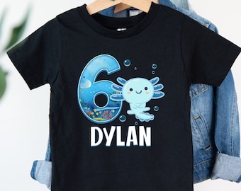 May include: Black t-shirt with a blue number 6, an axolotl, and the name "DYLAN" printed on it.