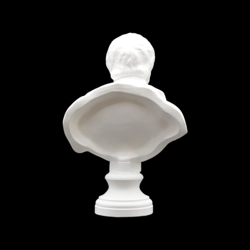 May include: A white bust sculpture, viewed from the back, set against a black background. The sculpture features a detailed depiction of a person's head and shoulders, with a classic, neoclassical style. The bust is mounted on a pedestal.