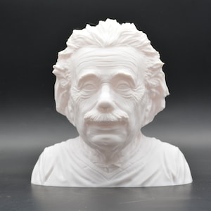 Peut inclure: Buste en plâtre blanc d'Albert Einstein. La sculpture représente la tête et les épaules d'Einstein avec ses cheveux sauvages et sa moustache caractéristiques.