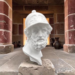 Può includere: Un busto scultoreo bianco di una figura barbuta che indossa un elmo dettagliato con una cresta prominente. La scultura presenta peli facciali intricati, lineamenti definiti e una finitura opaca e liscia.