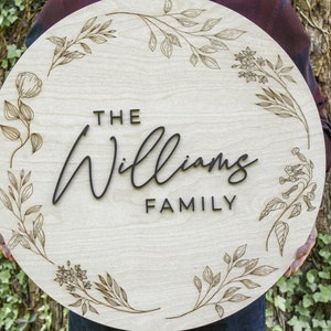 Round Family Last Name Sign with Engraved Botanical Frame and Raised Calligraphy Lettering