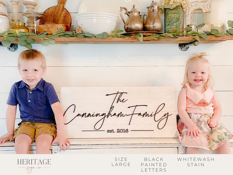 May include: A whitewash stained wooden sign with the text "The Cunningham Family est. 2016" in black painted script lettering.