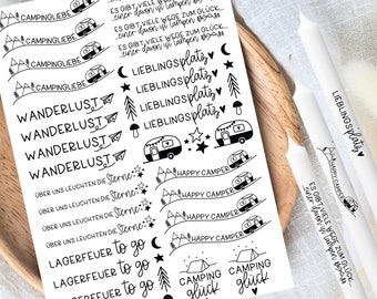 Op de afbeelding: Zwart-witte stickerblad met camping- en reisontwerpen. De stickerblad bevat zinnen zoals "Wanderlust", "Happy Camper", "Camping Glück" en "Lieblings Platz".