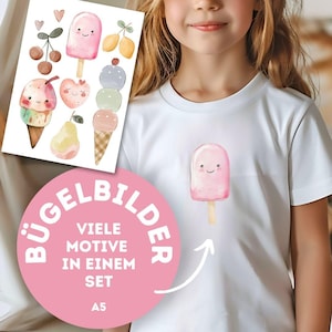 Könnte beinhalten: Weißes T-Shirt mit einer Illustration eines lächelnden rosa Eis am Stiel. Ein Bogen mit Eiscreme- und Fruchtaufklebern ist sichtbar. Der Bogen hat verschiedene Eistüten, Kirschen und Birnen. Der Text "BÜGELBILDER" ist sichtbar.