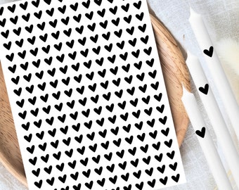 Op de afbeelding: Een vel met zwarte hart stickers op een witte achtergrond. Het vel is gevuld met kleine zwarte hartjes.
