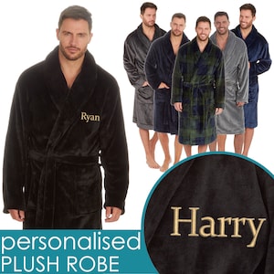 May include: Black plush robe with a gold embroidered name "Ryan". The robe has a shawl collar and a tie belt. The image also shows other robes in different colors and patterns, including a blue plaid robe and a gray robe.