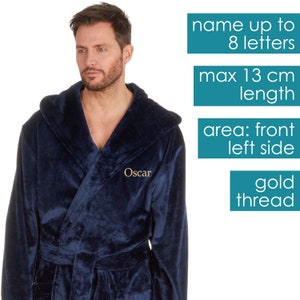 May include: A navy blue hooded robe with a gold thread embroidered name "Oscar" on the front left side. The robe has a belt and a hood. The text on the image says "name up to 8 letters", "max 13 cm length", "area: front left side", and "gold thread".