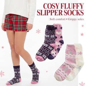 May include: Cosy fluffy slipper socks with grippy soles. The socks feature various patterns including snowflakes, hearts, and stars in shades of pink, white, and dark purple. Text on the image reads: COSY FLUFFY SLIPPER SOCKS. Soft comfort • Grippy soles.