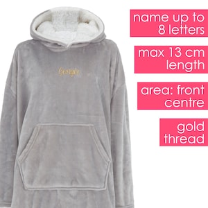 May include: Grey hooded blanket with a large pocket on the front. The blanket is made of soft fleece and has a sherpa lining. The word "Georgia" is embroidered on the front in gold thread.