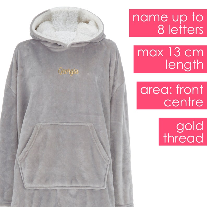 May include: Grey hooded blanket with a large pocket on the front. The blanket is made of soft fleece and has a sherpa lining. The word "Georgia" is embroidered on the front in gold thread.
