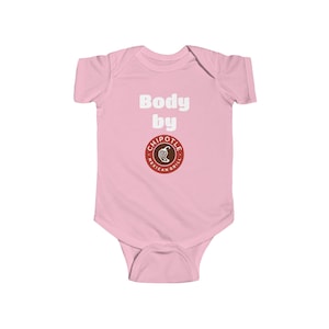May include: A light pink short-sleeve baby bodysuit featuring the white text Body by above a circular Chipotle Mexican Grill logo. The garment has a crew neckline and a snap closure at the bottom, providing a simple and functional design for infants.