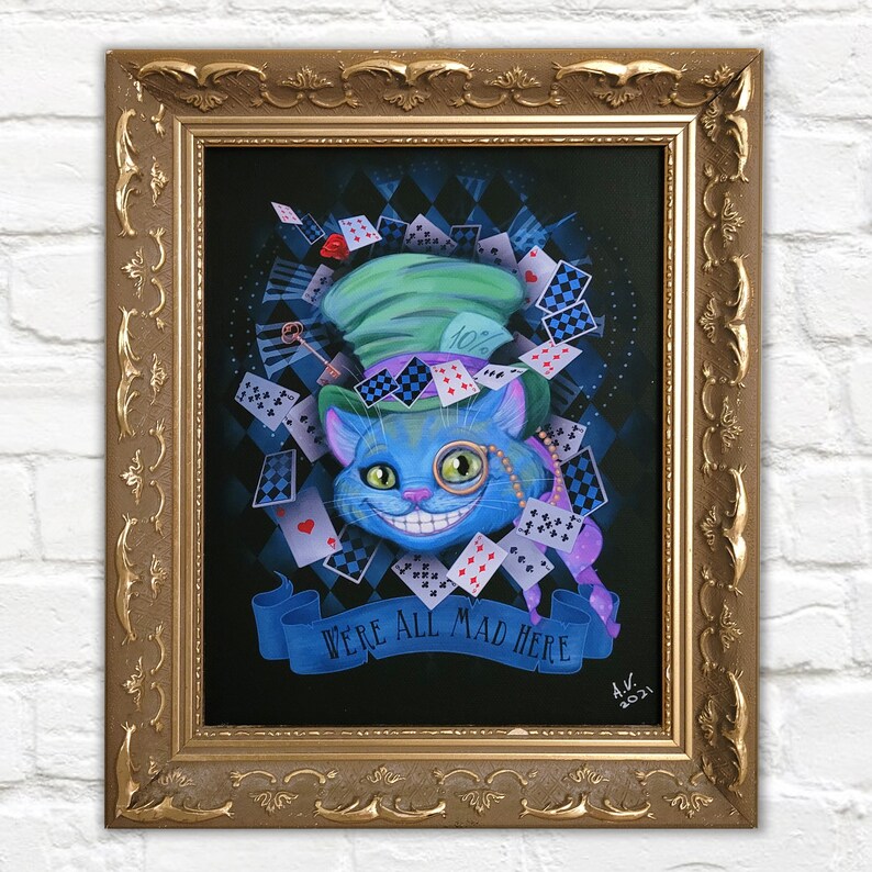 Op de afbeelding: Een blauwe Cheshire Cat met een ondeugende grijns, die een groene hoge hoed draagt met een 10% bordje. De kat is omringd door speelkaarten en de tekst "We're all mad here".