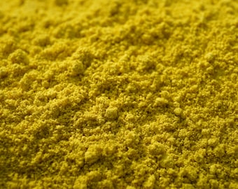 May include: Close-up of a pile of bright yellow turmeric powder.