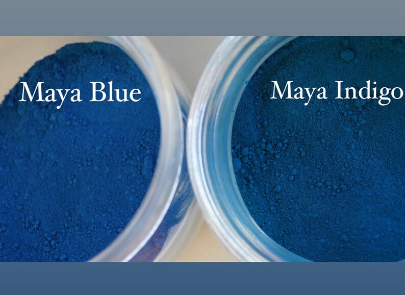 May include: Two small jars of blue pigment powder. The jar on the left is labeled "Maya Blue" and the jar on the right is labeled "Maya Indigo".
