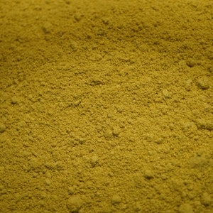 May include: A close-up view of a pile of yellow-green powder. The powder is finely ground and has a uniform texture.