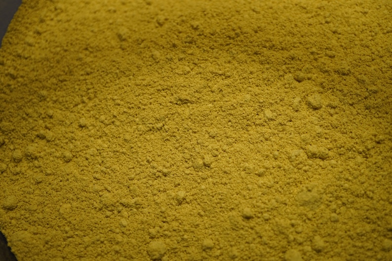 May include: A close-up view of a pile of yellow-green powder. The powder is finely ground and has a uniform texture.