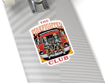 May include: A sticker featuring a red fire truck with two skeletons wearing firefighter helmets and holding axes. The text "THE FIREFIGHTER CLUB" is printed in yellow and red on the sticker.