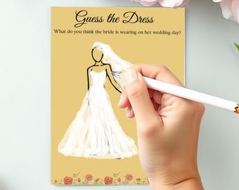 May include: A wedding game card with the text "Guess the Dress". The card features a sketch of a bride in a wedding dress, with a hand holding a pencil to draw on the card. The background is a light yellow colour with floral accents.