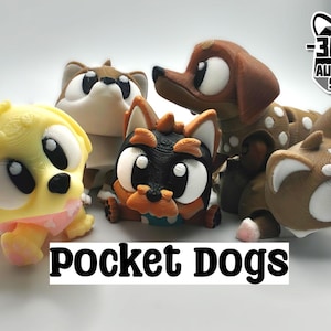May include: Five small, colourful, 3D printed toy dogs with large eyes. The dogs are in various poses and are made of different colours, including yellow, brown, black, and white. The text "Pocket Dogs" is printed below the dogs.