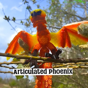 Könnte beinhalten: Articuliertes Phoenix-Spielzeug aus orangem und gelbem Kunststoff mit schwarzen Füßen und Flügeln. Das Spielzeug ist auf einem Ast mit grünem Hintergrund platziert.