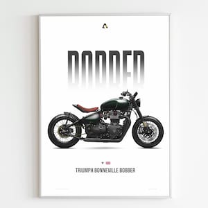 May include: A framed print featuring a dark green Triumph Bonneville Bobber motorcycle. The word "BOBBER" is printed in large, bold, gray letters above the motorcycle. The text "TRIUMPH BONNEVILLE BOBBER" is printed below the motorcycle.