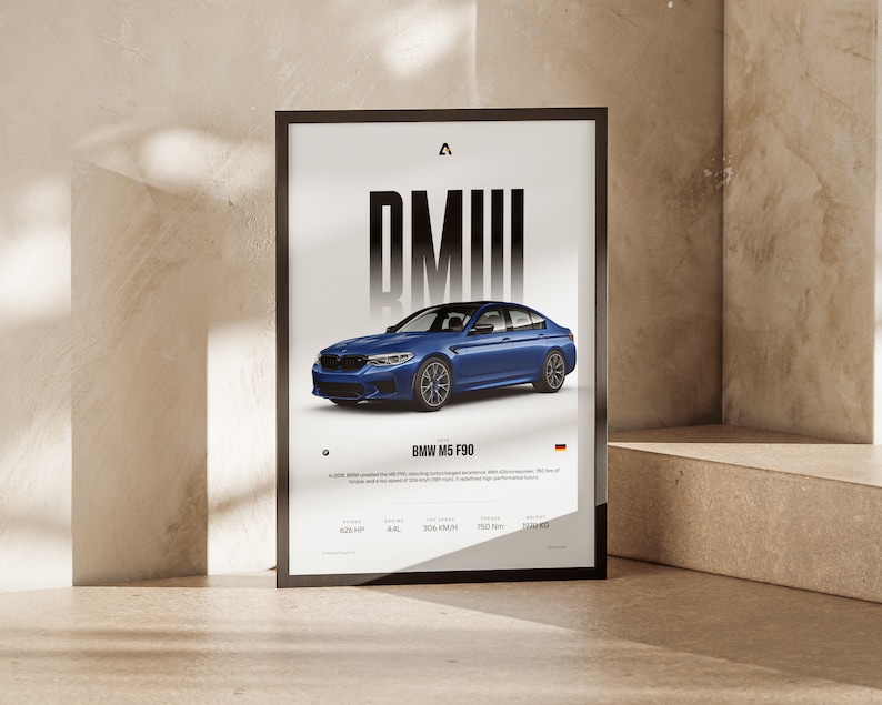 K&ouml;nnte beinhalten: Ein Poster mit schwarzem Rahmen, auf dem eine blaue BMW M5 F90 Limousine abgebildet ist. Das Poster zeigt den Text "BMW" in gro&szlig;en, fetten Buchstaben und enth&auml;lt die technischen Daten des Fahrzeugs: 625 PS, 4,4 l, 305 km/h, 750 Nm und 2240 kg.