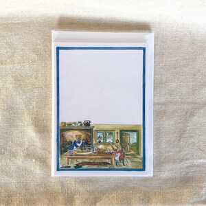 May include: A blank greeting card with a blue border and a watercolor illustration of two mice baking in a kitchen. The mice are wearing blue and red clothing and are surrounded by kitchen utensils and a fireplace.
