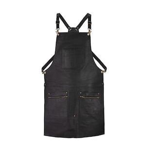 Könnte beinhalten: Schwarze Lederschürze mit verstellbaren Trägern, mehreren Taschen und Messingbeschlägen.