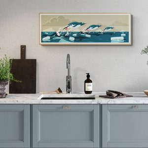 Long horizontal poster or art print hanging in a kitchen with artwork of three gentoo penguins that are making speed between the ice floes in the ocean around Antarctica. The panorama has shades of beige, white and blue colors.