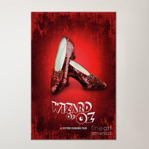 May include: A framed print of the Wizard of Oz movie poster. The poster features a pair of red sequined shoes and the movie title in white. The background is a deep red with a textured effect.
